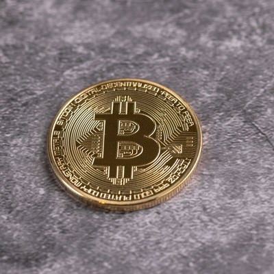 卓上に置かれた一枚の金貨（ビットコイン）の写真