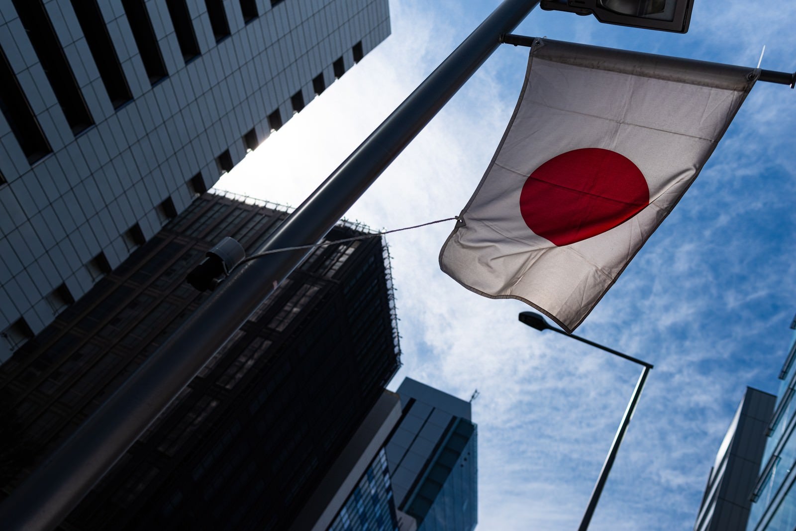 「ビル間から見える青空と日の丸の旗」の写真