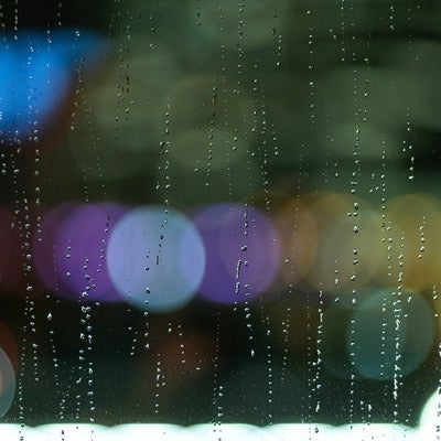 雨粒残る窓ガラスと煌めく光の写真