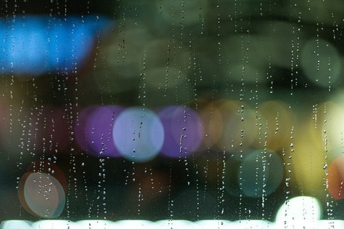 雨粒残る窓ガラスと煌めく光の写真