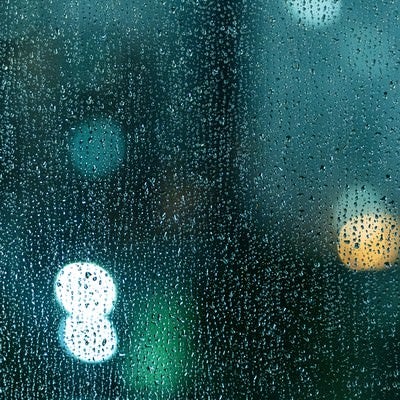ガラス窓いっぱいの雨粒の写真