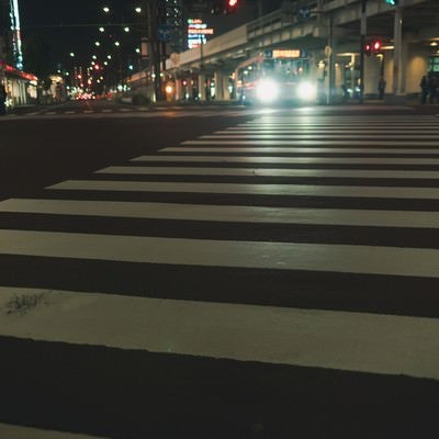 バスのヘッドライトと横断歩道の白線の写真