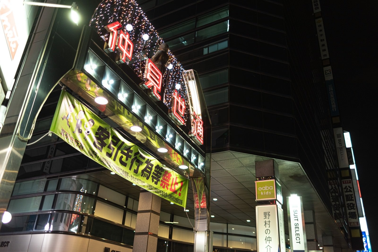 「川崎の仲見世通りの看板と客引き禁止の横断幕」の写真