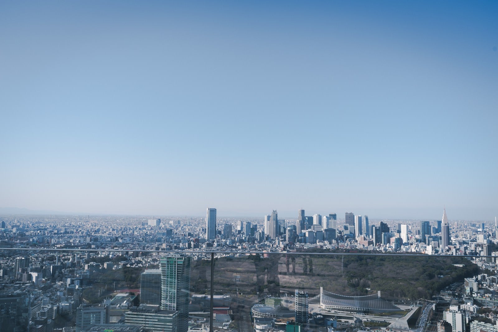 「雲一つない空と遠くに見る新宿ビル群」の写真