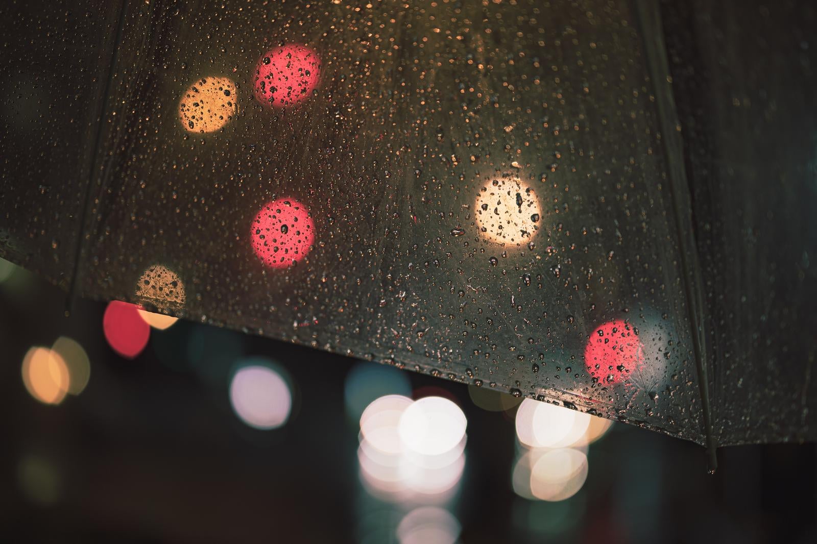 「傘の雨粒と街灯の丸ボケ」の写真