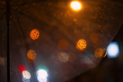 傘越しの雨粒と丸ボケの写真