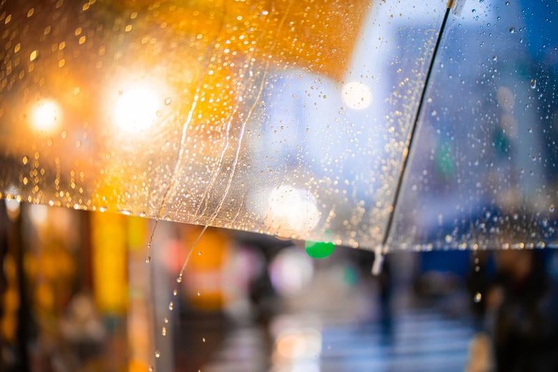 雨粒が滴るビニール傘と街明かり