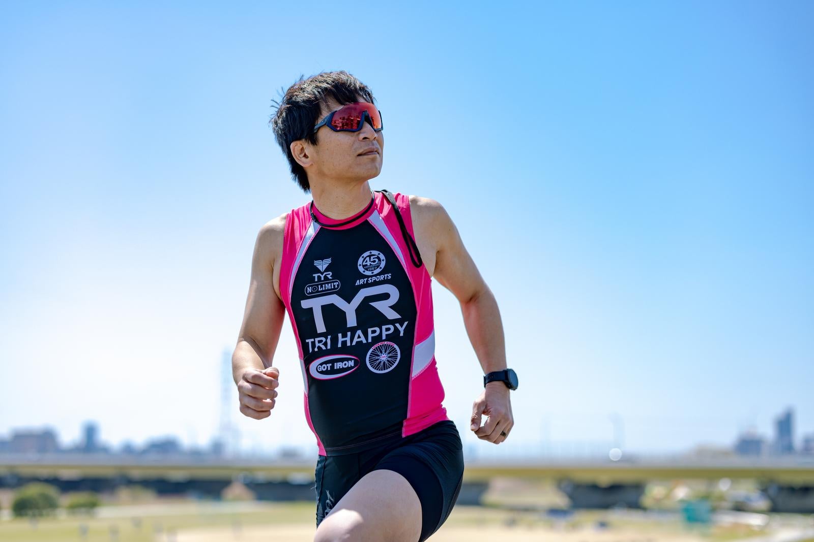 「サングラス姿でランニングする男性」の写真［モデル：うえせい］