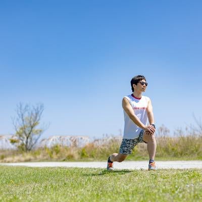 ランニング前に準備体操をする男性の写真