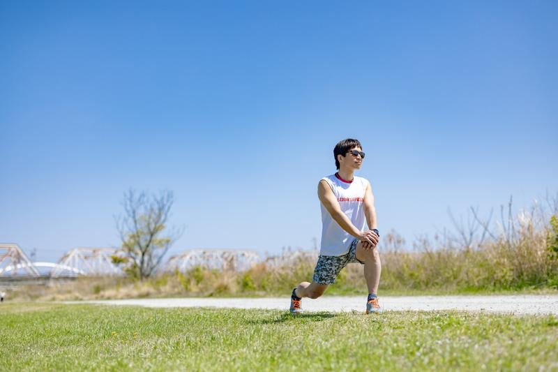 ランニング前に準備体操をする男性の写真
