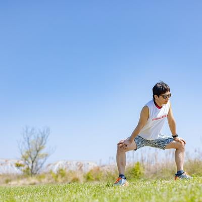 ランニング前に準備体操をする男性の写真