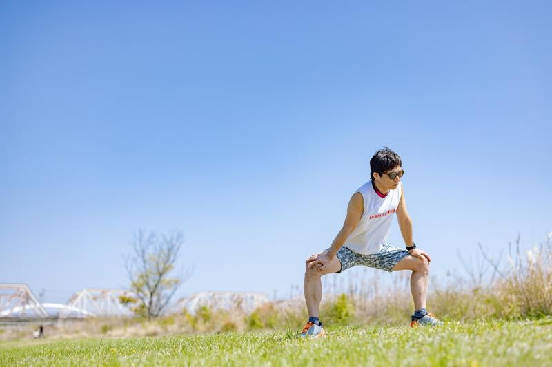 ランニング前に準備体操をする男性の写真