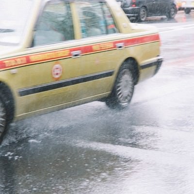 大雨で大忙しのタクシーの写真
