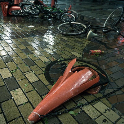 大型の台風の後、なぎ倒された三角コーンと自転車の写真