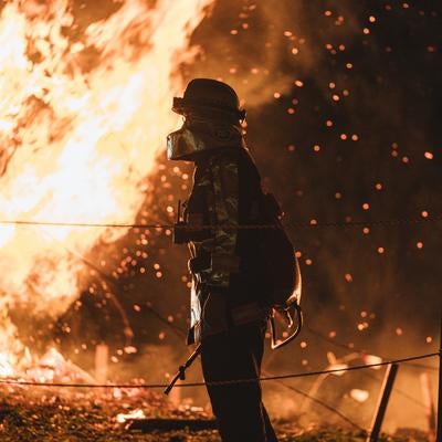 松明あかしの火の粉と消防員の写真
