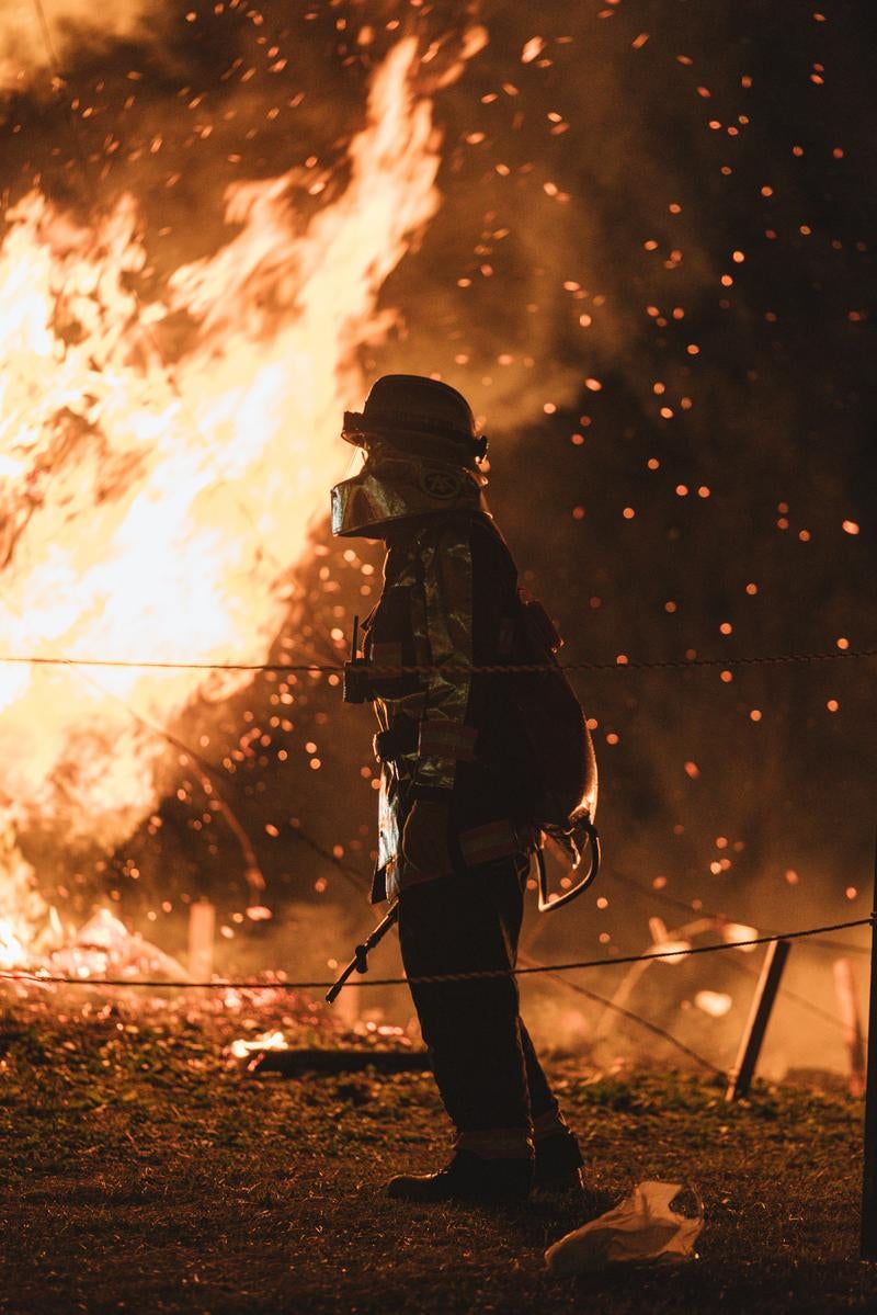 「松明あかしの火の粉と消防員」の写真