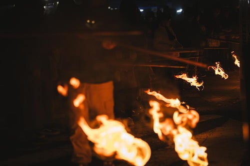 小松明行列で運ばれていく奉納する火の玉の写真