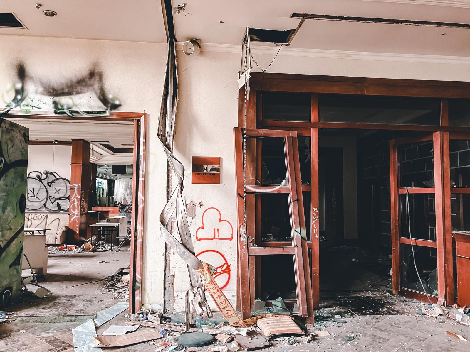落書きと割れたガラスが散らばる倒壊した廃屋のコーヒーショップ跡