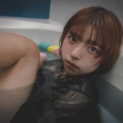 浴槽によりかかりこちらを見つめる女性の写真