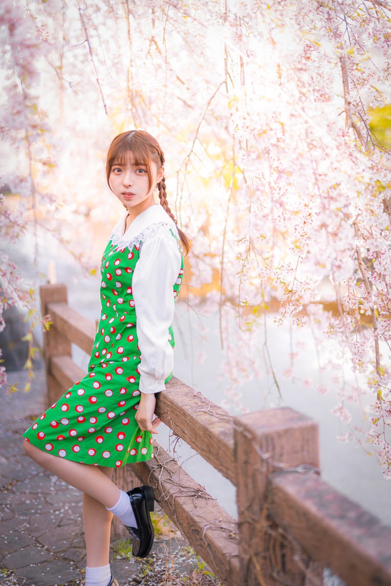 「河川に咲くしだれ桜に包まれる女性」の写真［モデル：高尾実生］