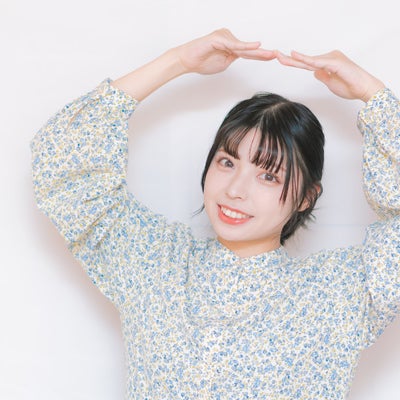 ハート型の手で「OK出ました！」と笑顔の女性の写真