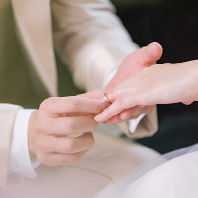 新婦の左の薬指に結婚指輪をつける様子の写真