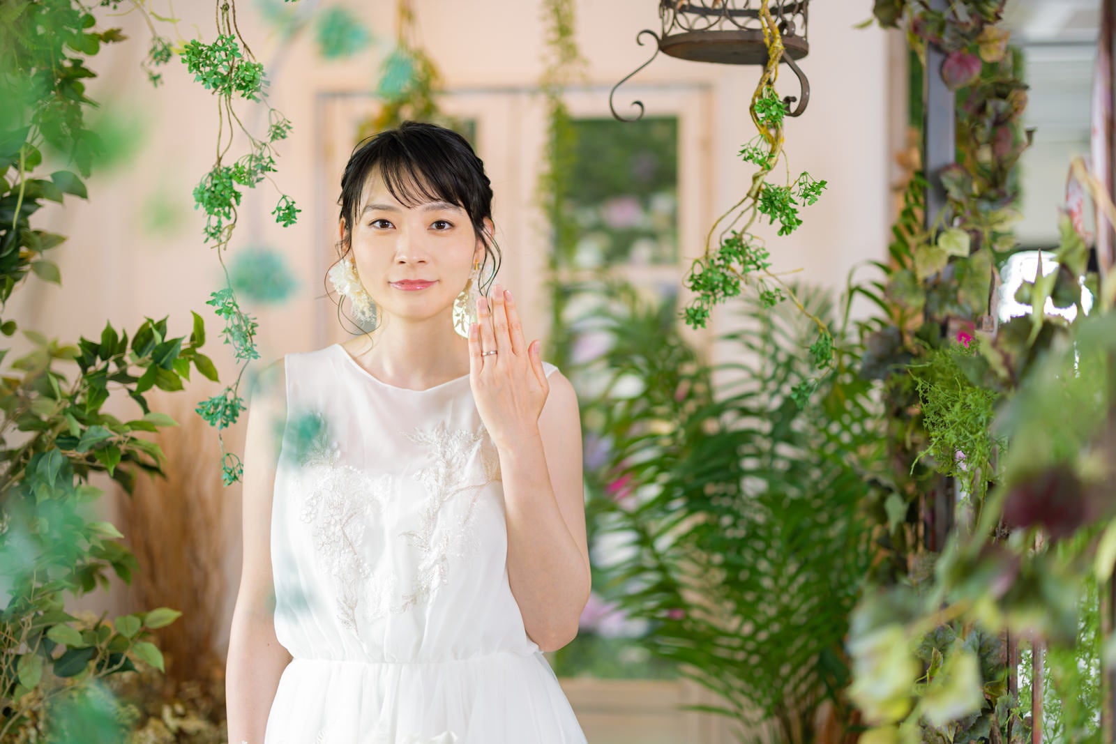 「結婚指を見せるウェディングドレス姿の女性」の写真［モデル：たけべともこ］