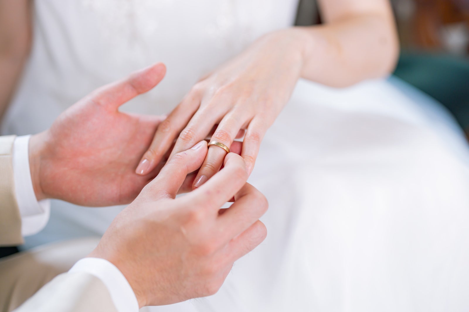 「左の薬指に結婚指輪をはめる」の写真［モデル：たけべともこ］