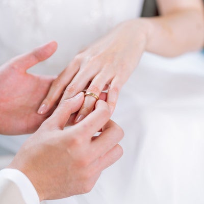 左の薬指に結婚指輪をはめるの写真
