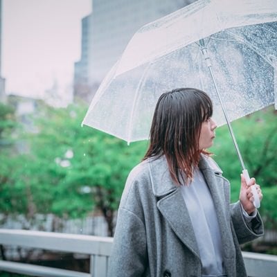 傘を差して散歩する女性の写真