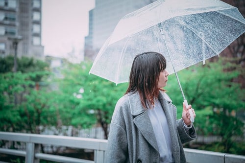 傘を差して散歩する女性の写真