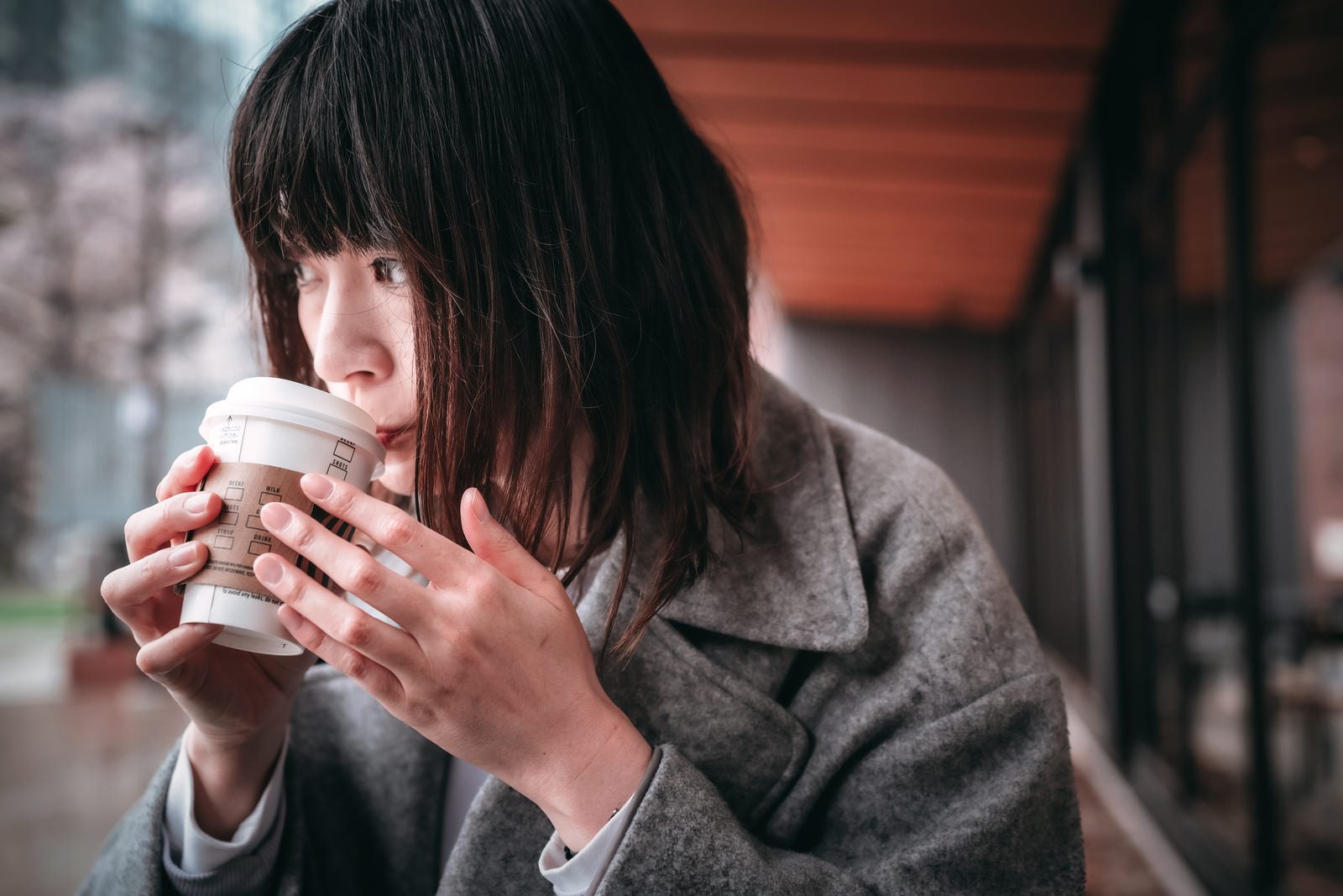 「ホットコーヒーを啜る女性」の写真［モデル：たけべともこ］