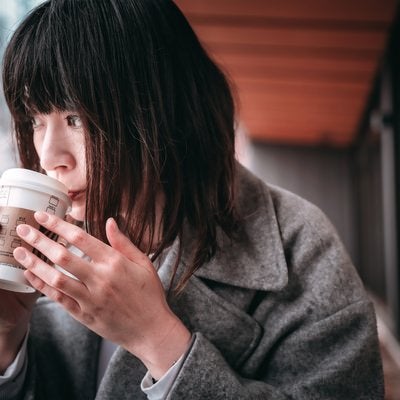 ホットコーヒーを啜る女性の写真