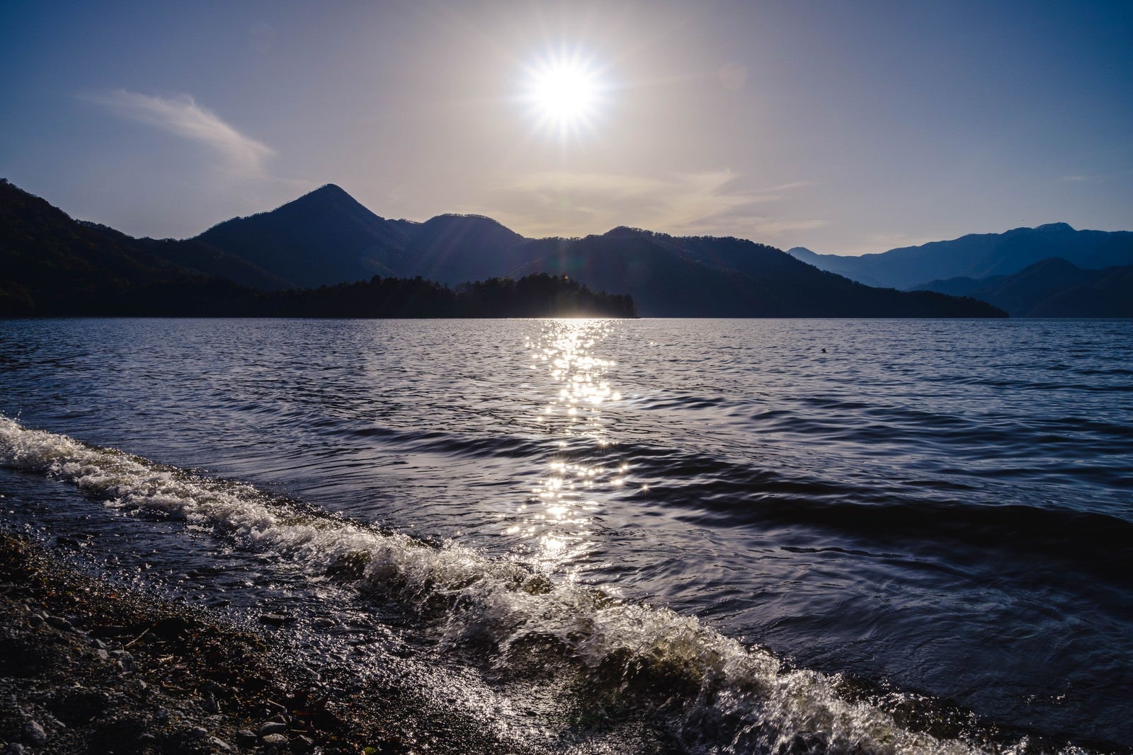 「日光中禅寺湖の沈みゆく夕陽と社山」の写真