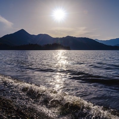 日光中禅寺湖の沈みゆく夕陽と社山の写真