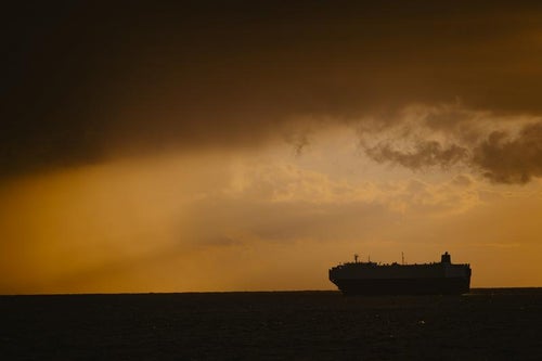雨雲の先のタンカーの写真