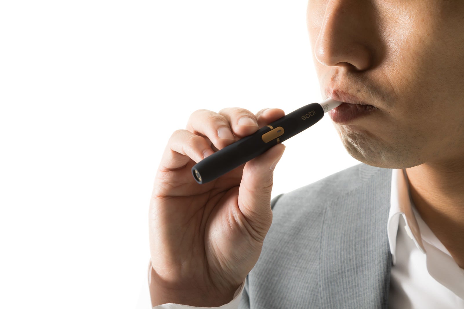 「加熱式たばこを吸う男性の口元」の写真［モデル：大川竜弥］