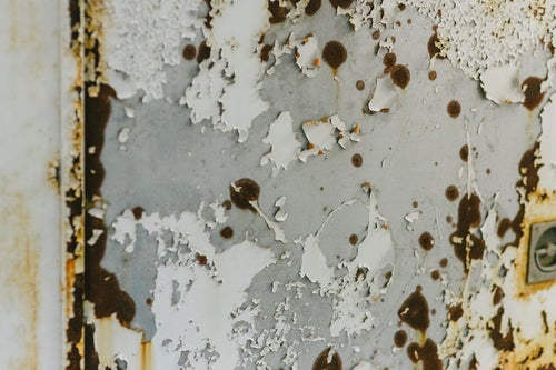 塗装が錆て剥がれ落ちたドアの写真