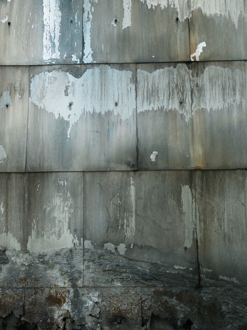 「下部が崩れかけるコンクリートの壁（テクスチャー）」の写真