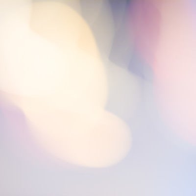 淡いボケた街明かりとネオンの光が優しく重なる夜景背景の写真