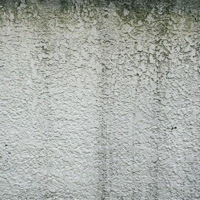 汚れが流れ落ちるモルタルの壁（テクスチャ）の写真