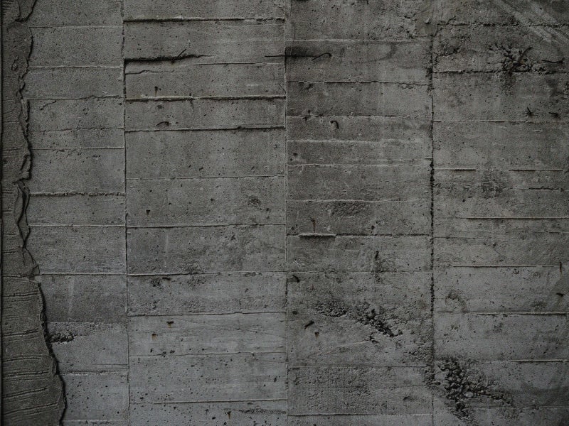 コンクリート壁に残る細かい枠板跡の写真