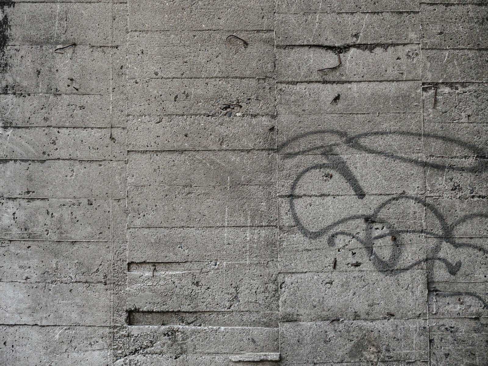 「落書き残るコンクリート壁」の写真
