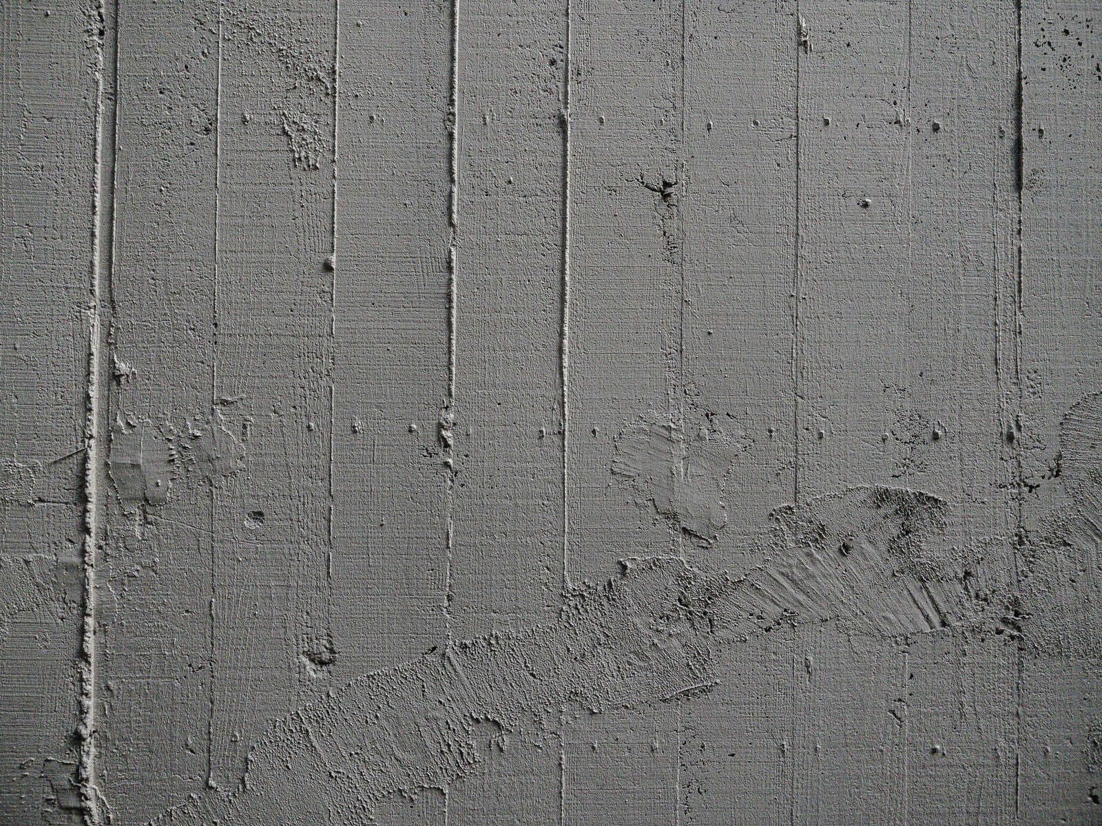 「コンクリート壁の枠板跡と補修跡」の写真