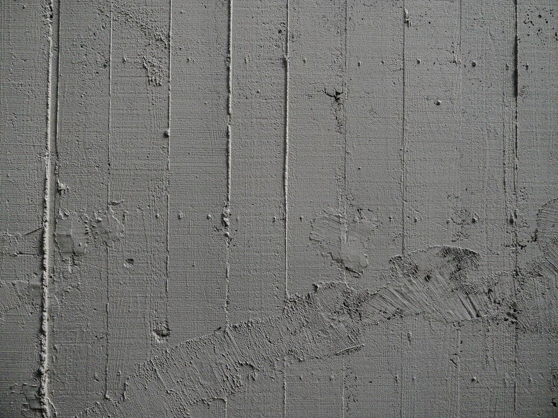 コンクリート壁の枠板跡と補修跡の写真
