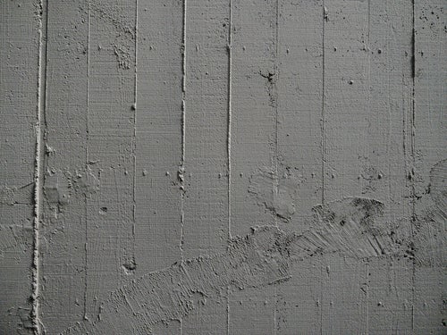 コンクリート壁の枠板跡と補修跡の写真