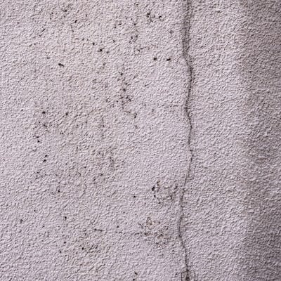 ひび割れを補修したモルタル壁のテクスチャーの写真