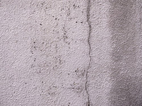 ひび割れを補修したモルタル壁のテクスチャーの写真