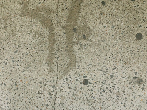 コンクリートに残るヒビとシミのテクスチャの写真