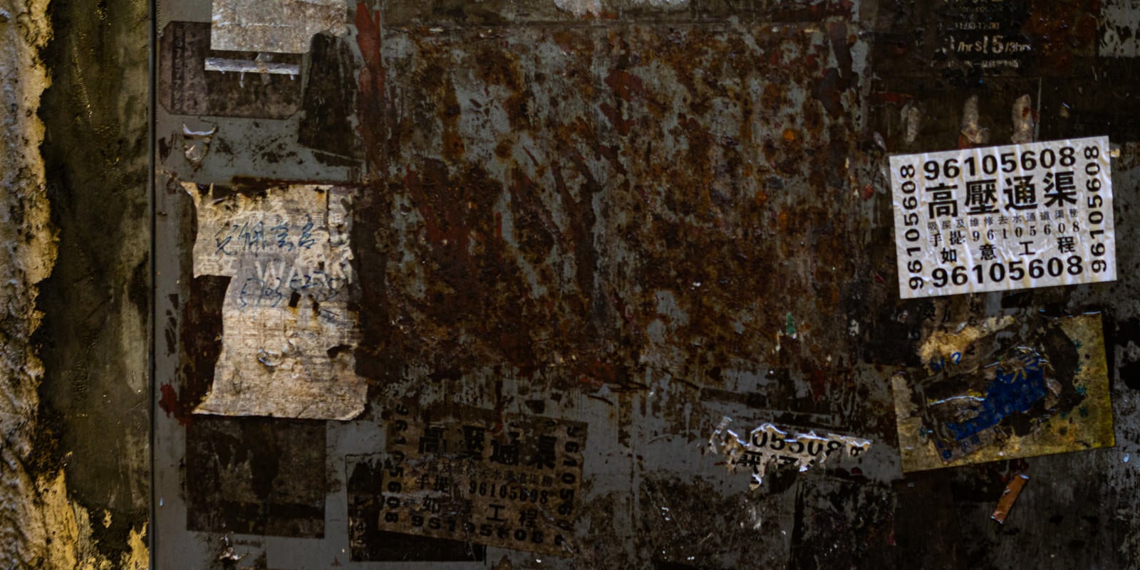 「錆びついて腐食した扉と貼られたチラシ」の写真